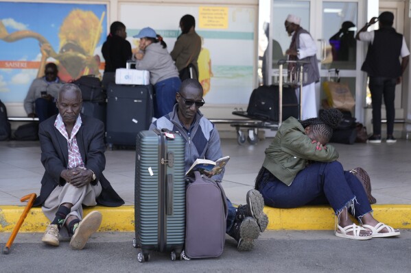 Stranded passengers wait for their delayed flights out of JKIA airport after flights were grounded following workers’ protesting a planned deal between the government and a foreign investor, in Nairobi, Kenya, Wednesday, Sept. 11, 2024. (AP Photo/Brian Inganga)