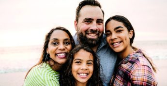 Smiling parents with two children on the beach