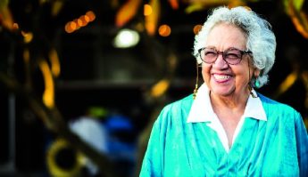 Older woman wearing glasses smiling. 