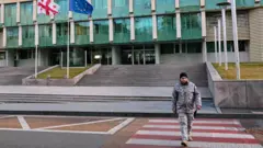 Здание и флаги Грузии и ЕС