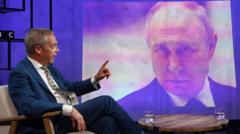 Найджел Фарадж перед экраном с изображением Владимира Путина во время интервью Би-би-си 21 июня
