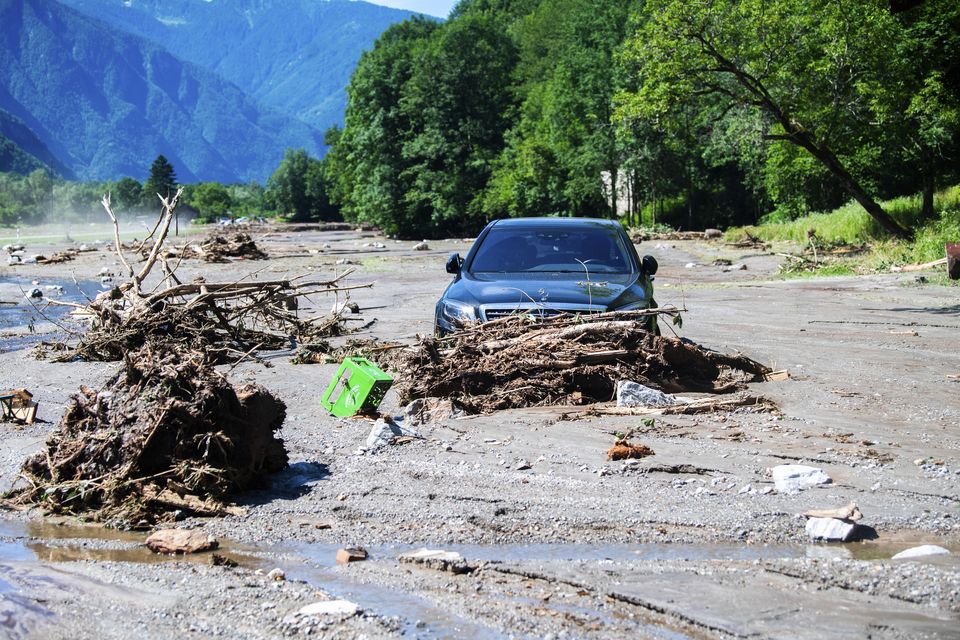 A car stuck in the mud at Sorte village after a landslide caused by the bad weather and heavy rain in the Misox valley, in Lostallo, southern Switzerland (Samuel Golay/Keystone via AP)