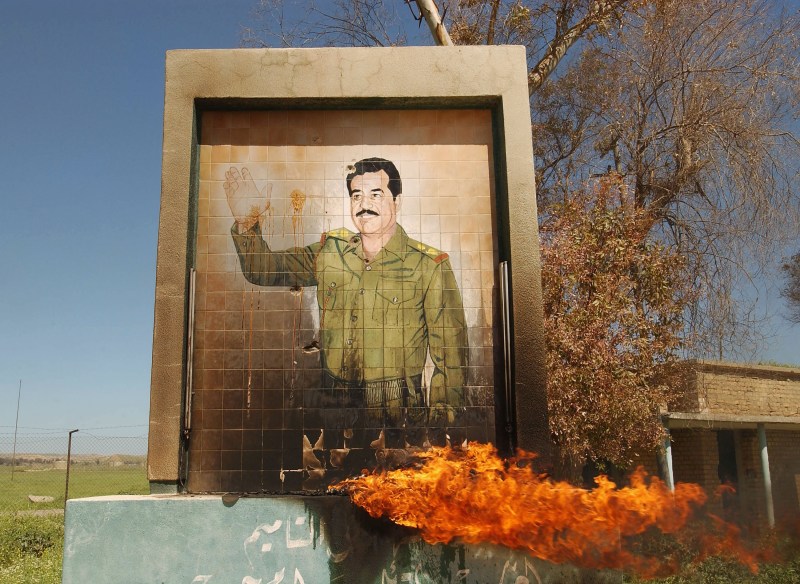 A burning mural of Saddam Hussein in Kirkuk on April 11, 2003. (Patrick Barth/Getty Images)
