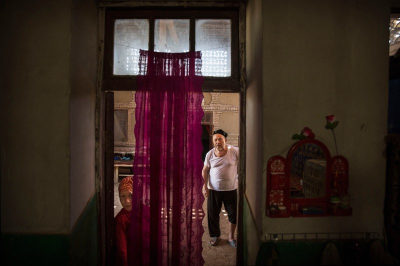 A Uighur man and his granddaughter are seen in their home after a meal during the Corban Festival, known to Muslims worldwide as Eid al-Adha or “feast of the sacrifice,” in China’s far western Xinjiang province on Sept. 12, 2016. (Kevin Frayer/Getty Images)