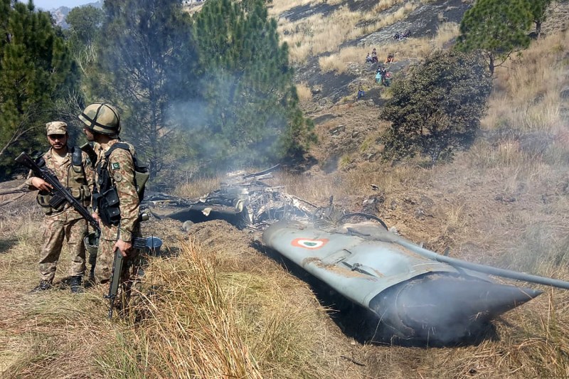 Pakistani soldiers stand next to what Pakistan says is the wreckage of an Indian fighter jet shot down in Pakistan-controlled Kashmir near the Line of Control on Feb. 27. (STR/AFP/Getty Images)