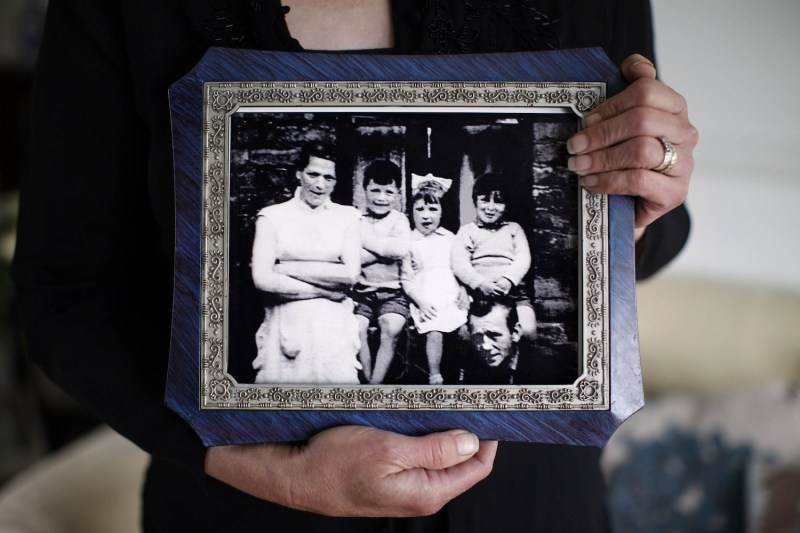 Helen McKendry, eldest daughter of Jean McConville, holds a family photograph showing her mother Jean McConville (left) and some of Jean's children including Helen herself (second from right), at her home in Northern Ireland on May 3, 2014. (Peter Muhly/AFP/Getty Images)