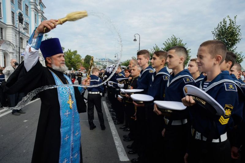 An Orthodox priest and cadets of the Nakhimov naval academy take part in the opening ceremony for the start of a new academic year known as the "Day of Knowledge" in Saint-Petersburg, on September 1, 2018.