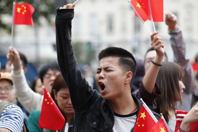 Counter-protesters wave Chinese flags in the Place Saint Michel, central Paris, as they oppose demonstrators gathering to support  protests in Hong Kong, on August 17, 2019.