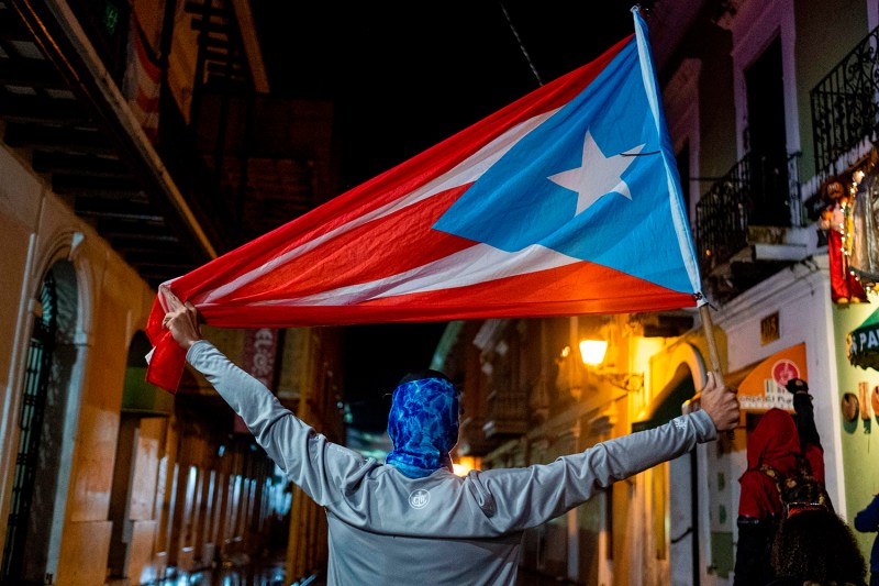 A protester holds a Puerto Rican flag during a demonstration against Puerto Rico's government in front of the governor's mansion in San Juan, Puerto Rico on Jan. 23.