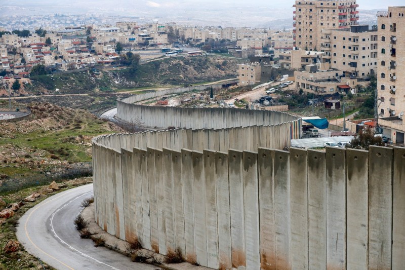 Israel's controversial separation wall runs between the Israeli settlement of Pisgat Zeev (left), built in a suburb of East Jerusalem, and the Palestinian Shuafat refugee camp (right) on Feb. 11.