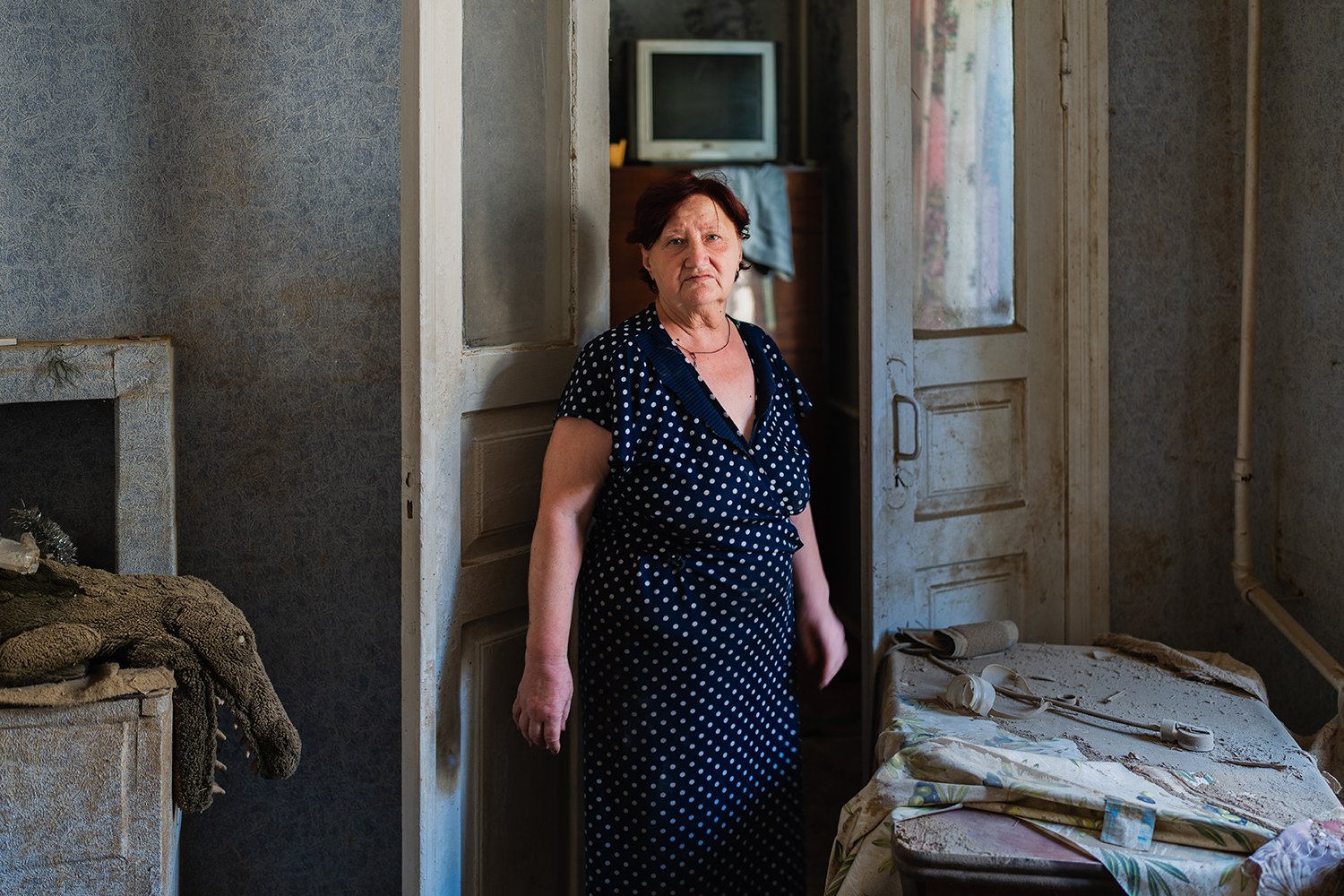 Antonina, 62, stands inside her house.