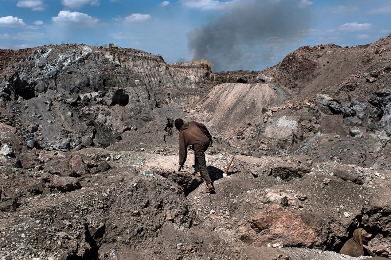 A worker climbs through a copper and cobalt mine, materials used in production of electric cars, in the Democratic Republic of the Congo.