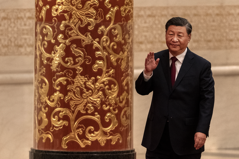 Chinese President Xi Jinping waves at press in the Great Hall of the People in Beijing on Oct. 23.