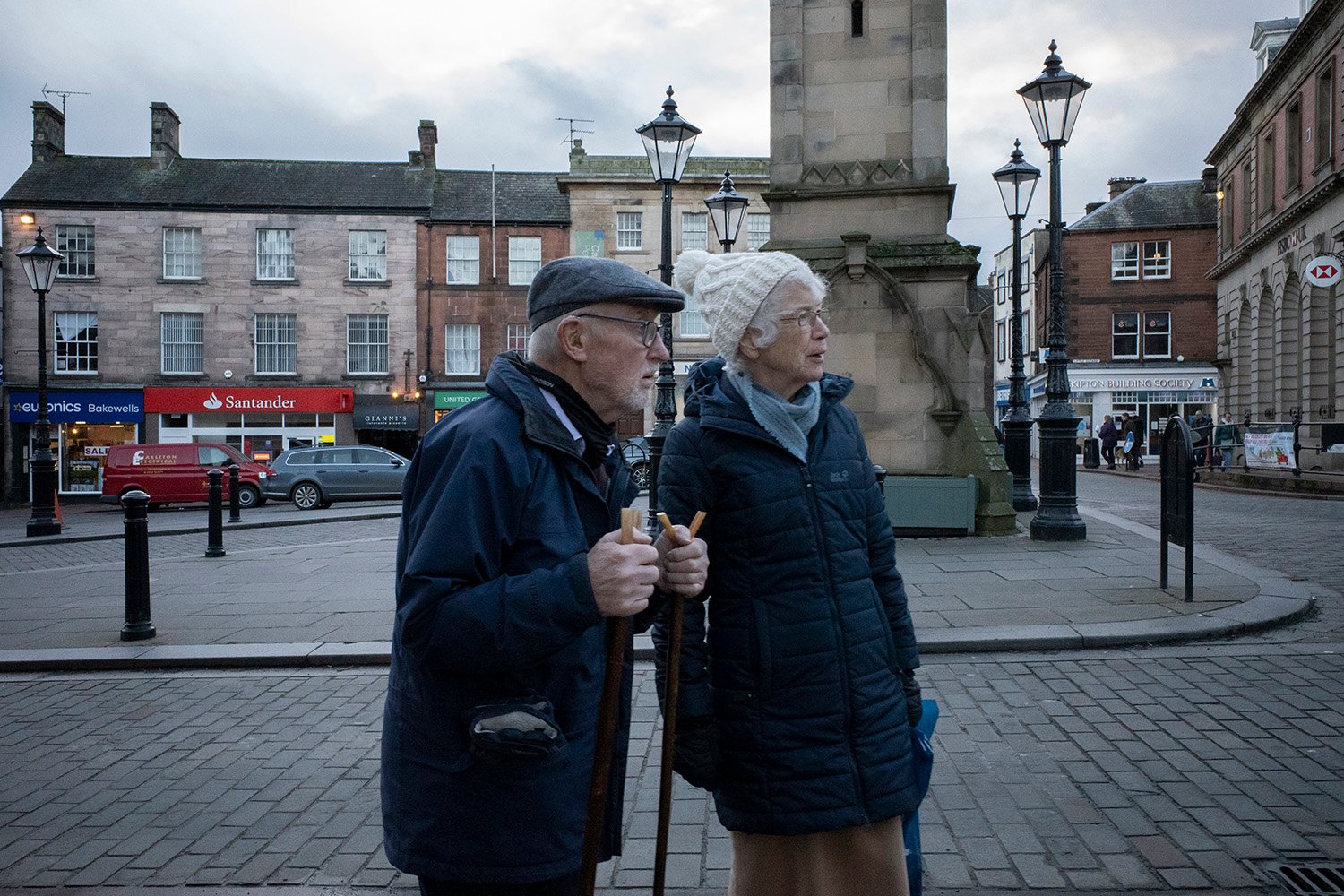 A man and woman walk through the streets of Penrith, Britain.