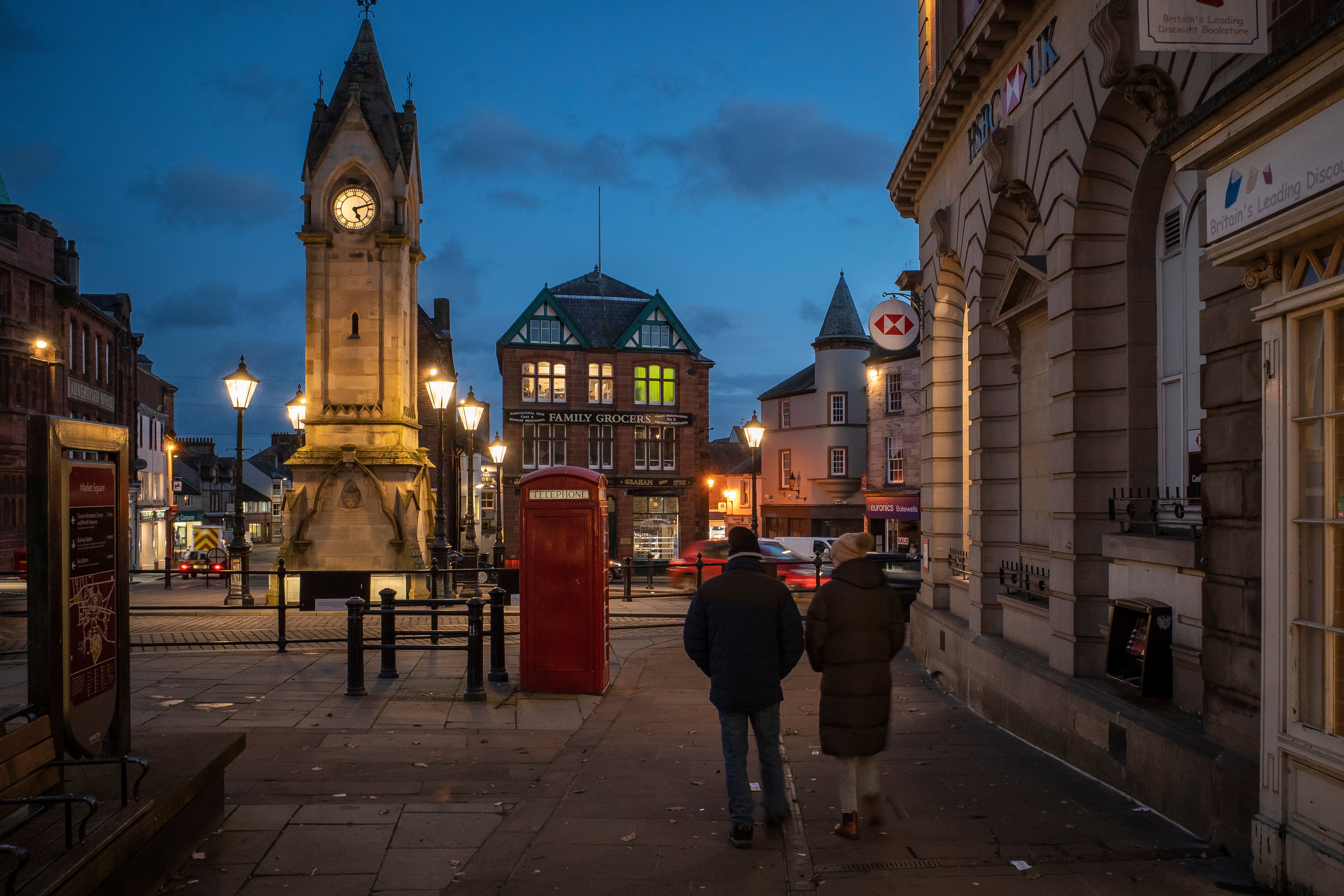 A couple walks along the dim streets of Penrith in the United Kingdom