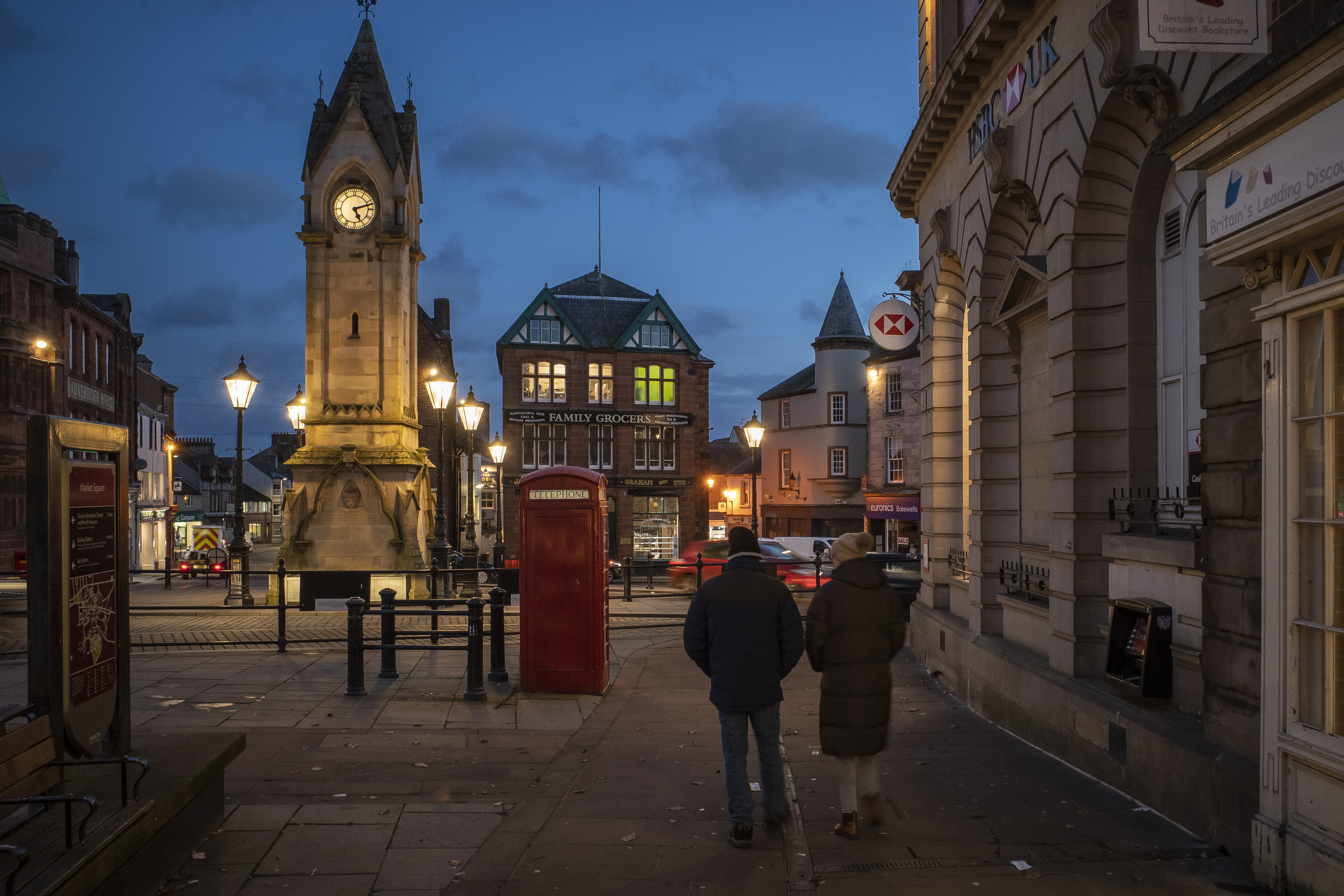 A couple walks along the dim streets of Penrith in the United Kingdom