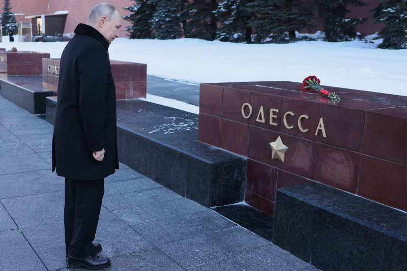 Russian President Vladimir Putin lays flowers at the Moscow Kremlin Wall in the Alexander Garden during an event marking Defender of the Fatherland Day in Moscow.