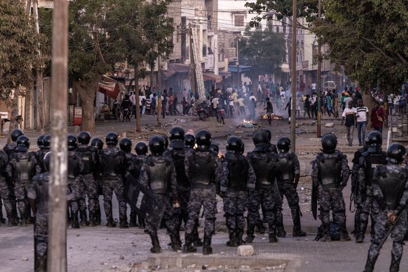 Senegalese gendarmes block a road after protesters burned tires and blocked roads in Dakar, Senegal's capital.