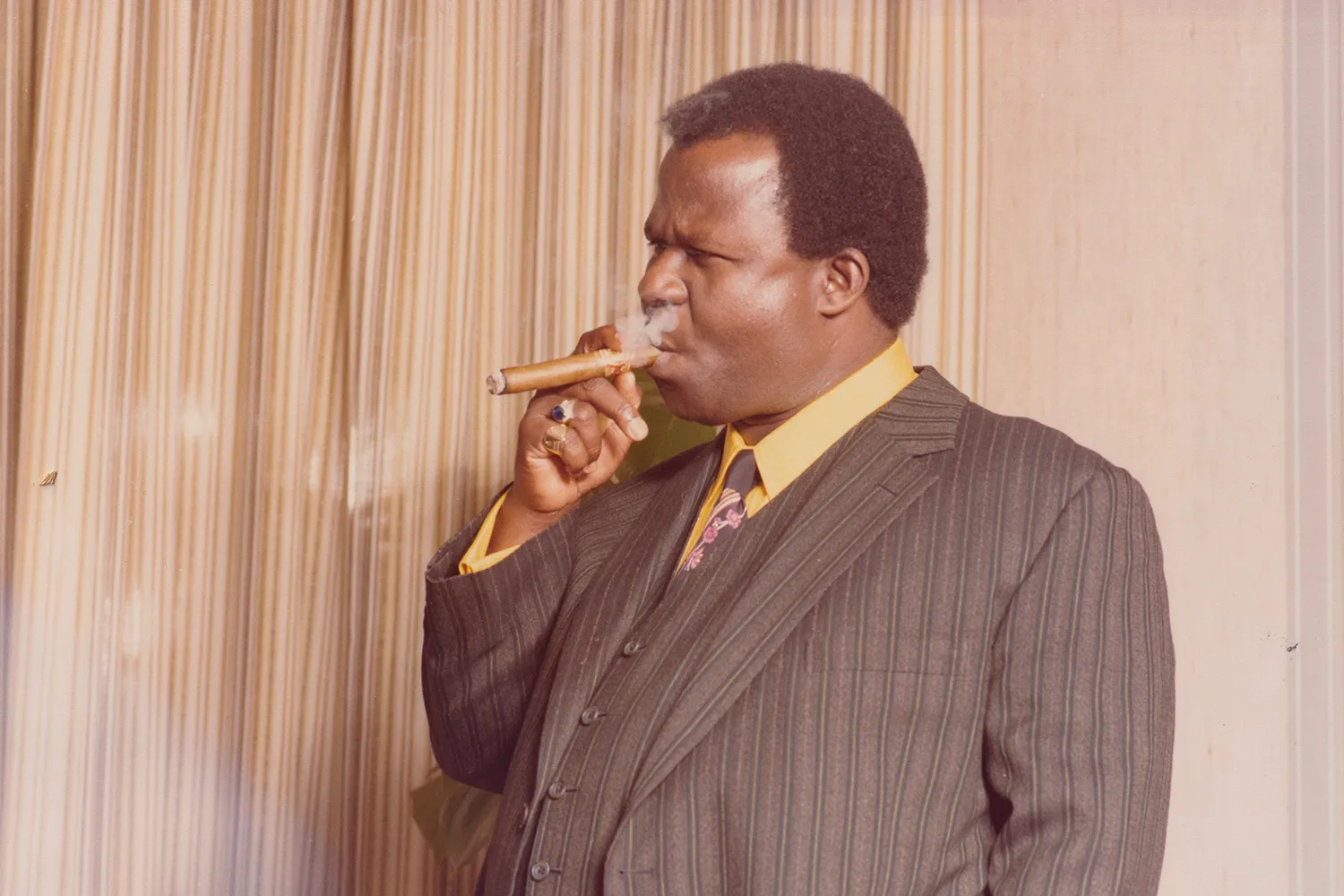 John Ackah Blay-Miezah smokes a cigar in the London office of the Oman Ghana Trust Fund in the 1980s.