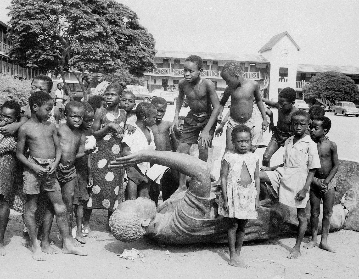 Children play around the fallen statue of Nkrumah in Accra, Ghana.