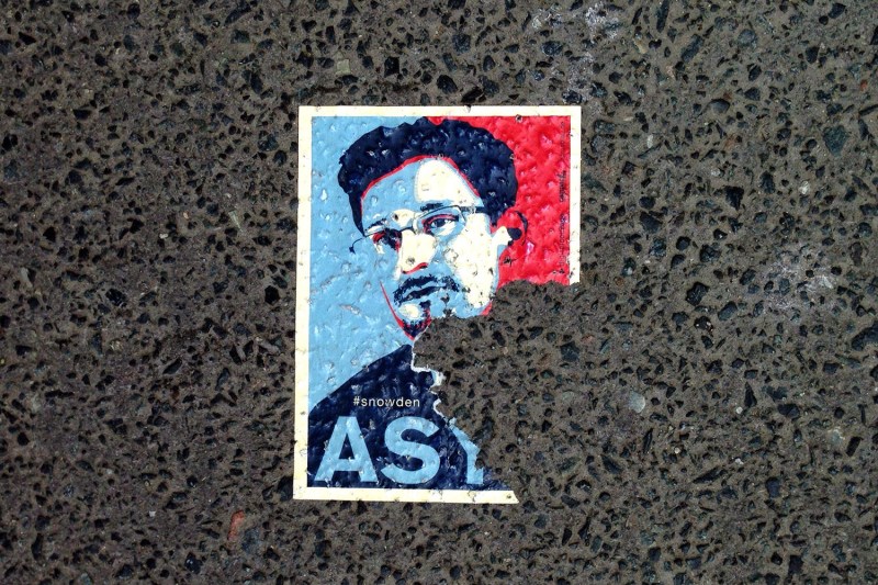 A sticker featuring U.S. intelligence leaker Edward Snowden and partially reading "asylum" is seen on the pavement of a Berlin street.