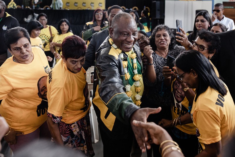 South African President Cyril Ramaphosa surrounded by a group of people.