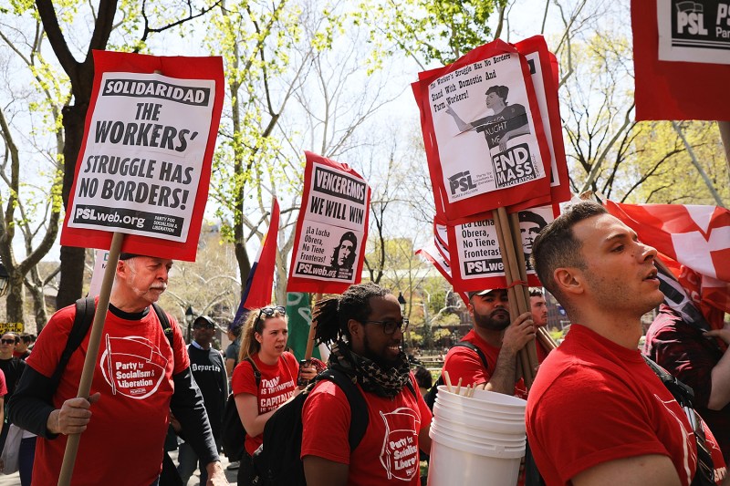 Dozens of people carrying socialist signs with workers rights messages march in New York on May 1, 2018.