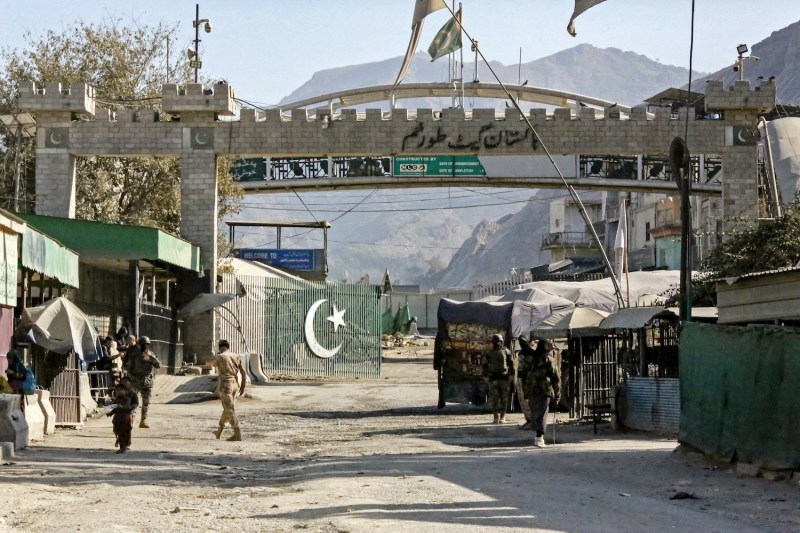 Afghan and Pakistani border security personnel stand guard at the Torkham border crossing between the two countries.