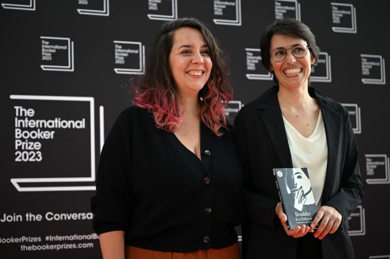 Spanish author Eva Baltasar, right, and Brazilian literary translator Julia Sanches, center, pose with the book “Boulder” on the red carpet upon their arrival for the International Booker Prize award ceremony in London on May 23, 2023.