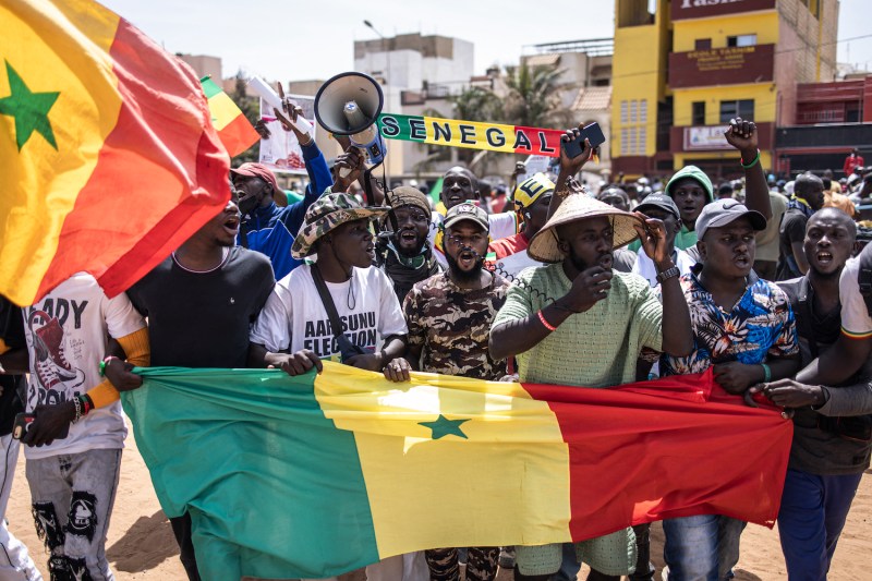 Opposition supporters chant and hold up Senegalese flags during a demonstration in Dakar.