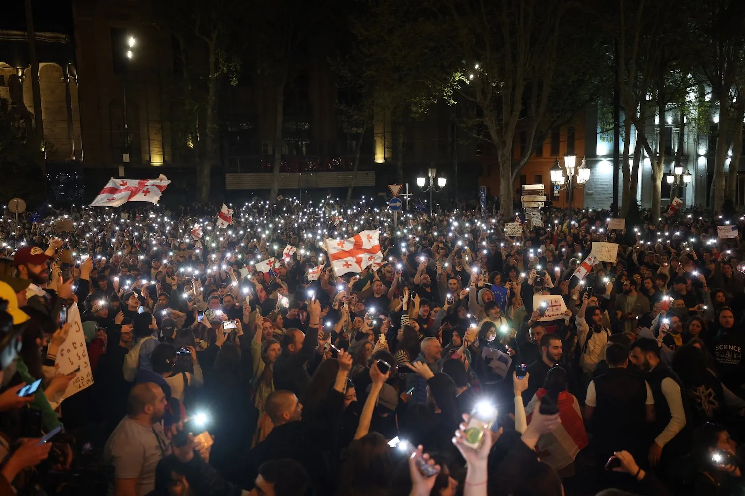 Protesters hold lights during a demonstration against a controversial draft bill on “foreign influence” outside the Georgian Parliament in Tbilisi on April 16.