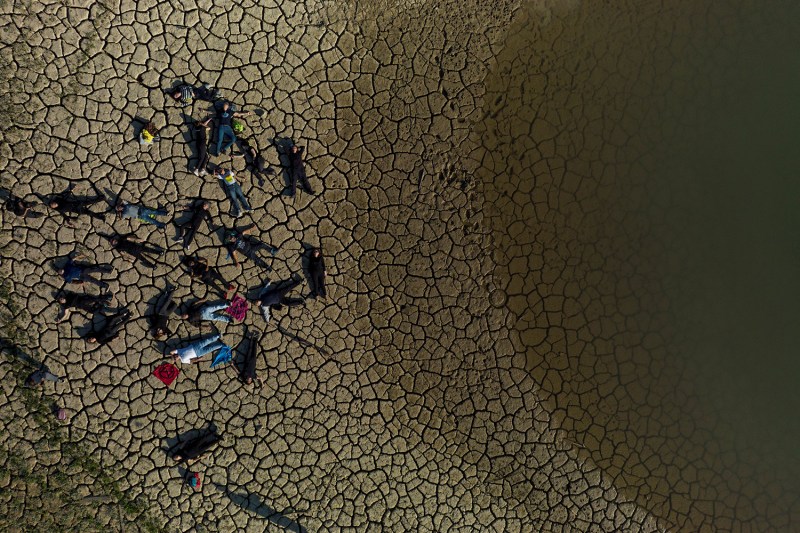 The view from above a group of people as they lay on scorched, dry ground.