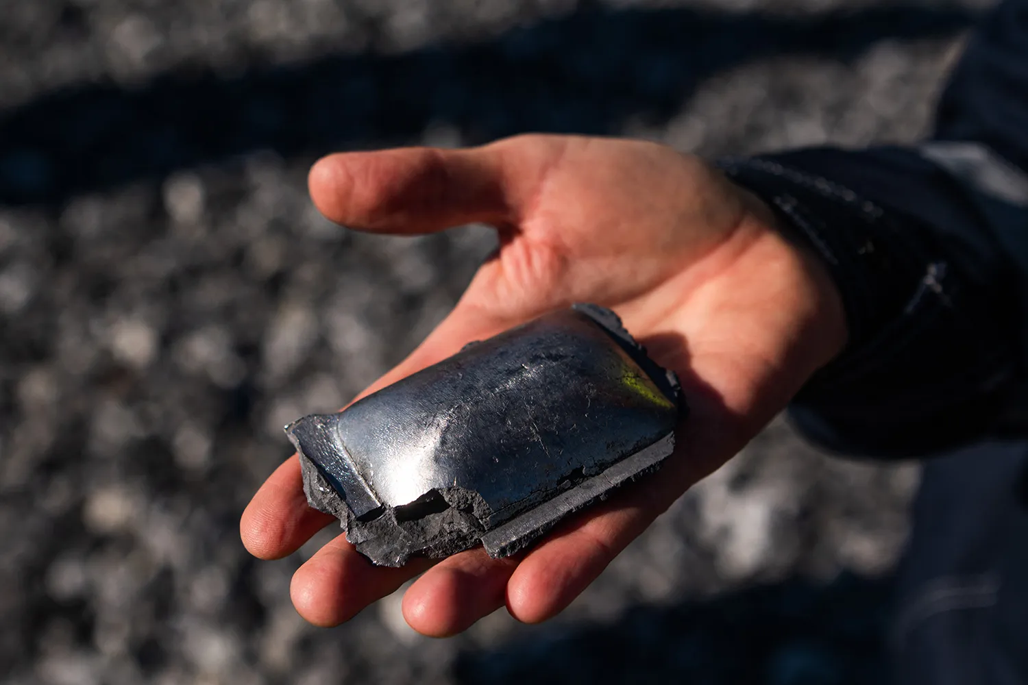 A steelmaker SSAB site manager holds up a piece of hot-briquetted iron