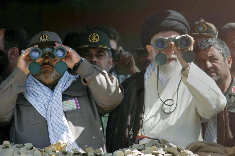 Iranian Supreme Leader Ayatollah Ali Khamenei and Hassan Firouzabadi, then head of the Iranian military, look through binoculars during the test firing of short- and medium-range missiles.