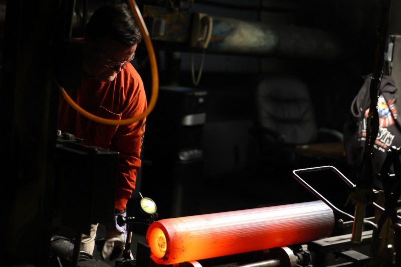 A worker inspects the form of the shaped steel billets following the “press” stage in the manufacturing process of 155 mm caliber shells at the Scranton Army Ammunition Plant in Scranton, Pennsylvania.