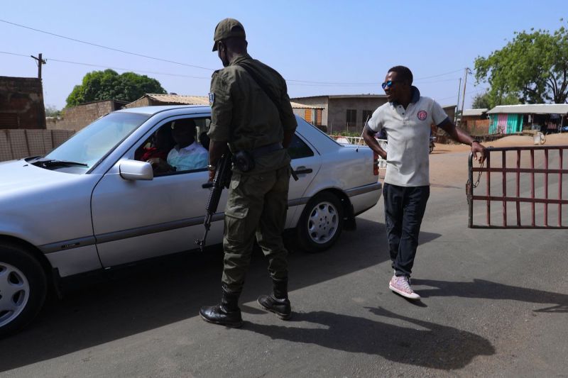 A security officer interacts with a driver at the Burkina Faso border with Ghana in Paga, northern Ghana, on Dec. 6, 2022.