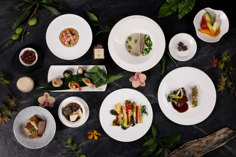 A top-down view of a number of Taiwanese dishes on a dark table.