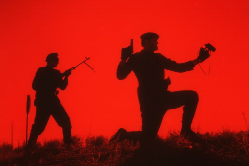 A red sky with two Soviet soldiers silhouetted in the foreground.