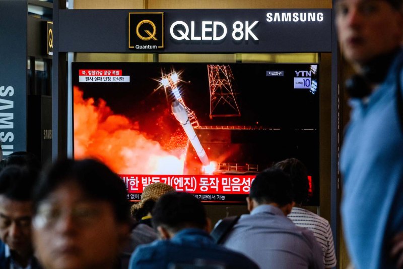 People pass a television showing footage of an attempted North Korean satellite launch during a news report at a train station in Seoul on May 28.