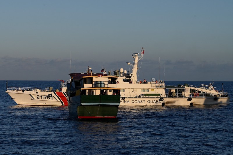 A China Coast Guard vessel sails near a Philippine military vessel in the disputed South China Sea.