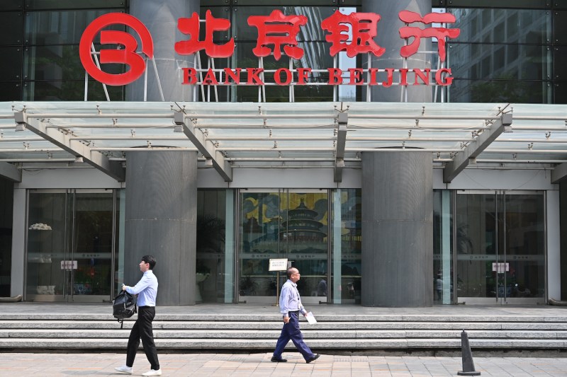 People walk past an office of the Bank of Beijing in Beijing on July 9.