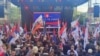 Građani okupljeni na skupu u Banjaluci 18. aprila, uglavnom, su nosili zastave RS, susjedne Srbije i ruskog predsjednika Vladimira Putina. Na jednom od transparenata je bila fotografija i Ratka Mladića, bivšeg komandanta Vojske RS kojeg je ICTY osudio za ratni zločin i genocid.