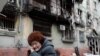 UKRAINE-CRISIS/MARIUPOL/A woman sits on a bench in front of a residential building heavily damaged during Ukraine-Russia conflict in the southern port city of Mariupol, Ukraine April 21, 2022. REUTERS/Alexander Ermochenko