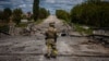 Украинский военный у разрушенного моста в Харьковской области, май 2022 года