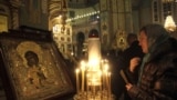 Верующая накануне рождественского богослужения в одном из православных храмов Риги