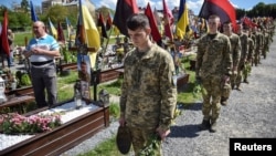 Ukrainian military cadets visit the graves of Ukrainian soldiers who were killed during Russia's invasion of Ukraine to mark the Orthodox feast of Palm Sunday at the Lychakiv cemetery in Lviv on April 28.