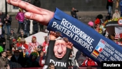Карнавал в Дюссельдорфе (Германия): фигура Владимира Путина поддерживает руку, воздетую в нацистском приветствии, на которой написаны названия ряда европейских правопопулистских партий