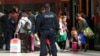 Germany, A police officer stands guard as migrants arrive at the main station in Munich, Germany September 5, 2015.