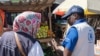 World Food Program officials look at fruit and vegetables in Zimbabwe's Chinhoyi district on June 12, 2024. Zimbabweans are trying to raise funds for survival as the country deals with an El Nino-induced drought. (Columbus Mavhunga/VOA)