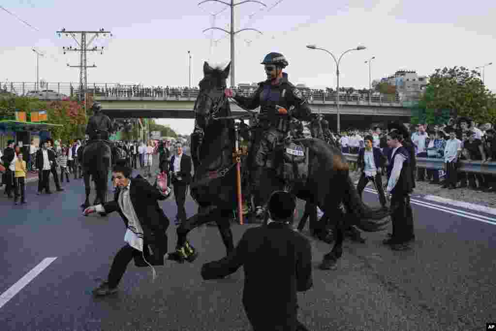 Israeli mounted police break up Ultra-Orthodox Jews blocking a highway during a protest against military recruitment in Bnei Brak, near Tel Aviv.